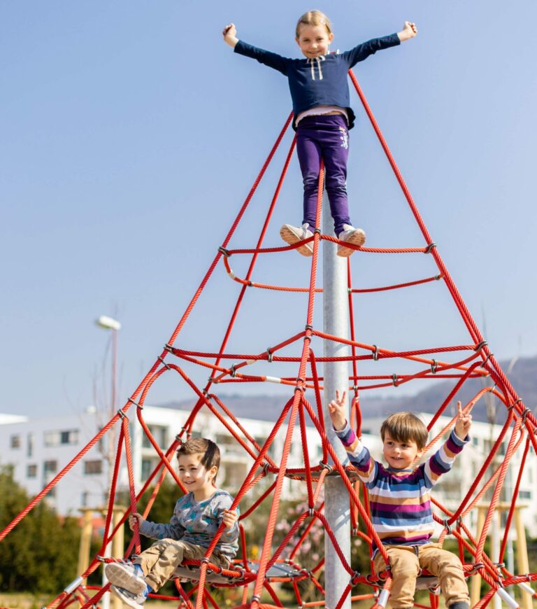 Bild von Kindern, die ein einem Seil-Turm klettern.