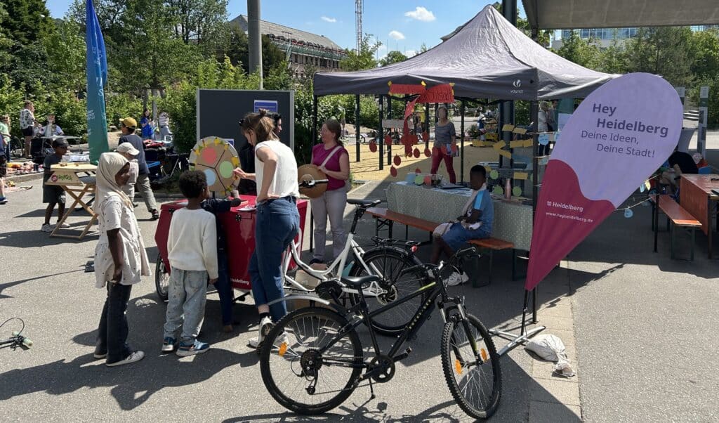 Das Bild ist von einem Stadtteilfest. Kinder können an einem Glücksrad drehen und danach ihre wichtigsten Orte in der Südstadt benennen.